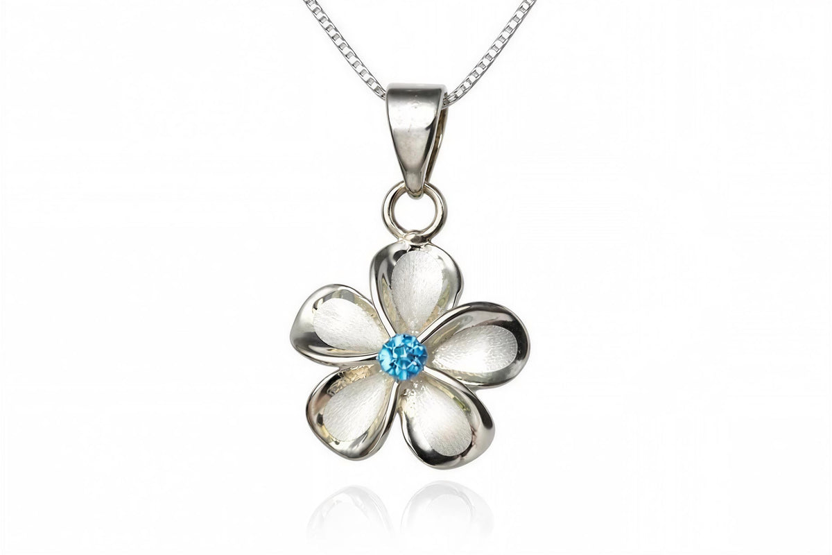 A silver pendant necklace with a silver flower-shaped pendant featuring a blue gemstone in the center.