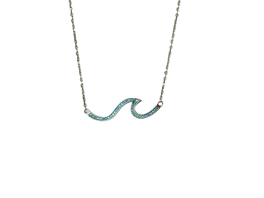 A necklace with a blue gemstone pendant in the shape of a wave.