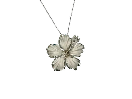 A silver-colored pendant necklace with a large, intricately designed flower-shaped pendant.