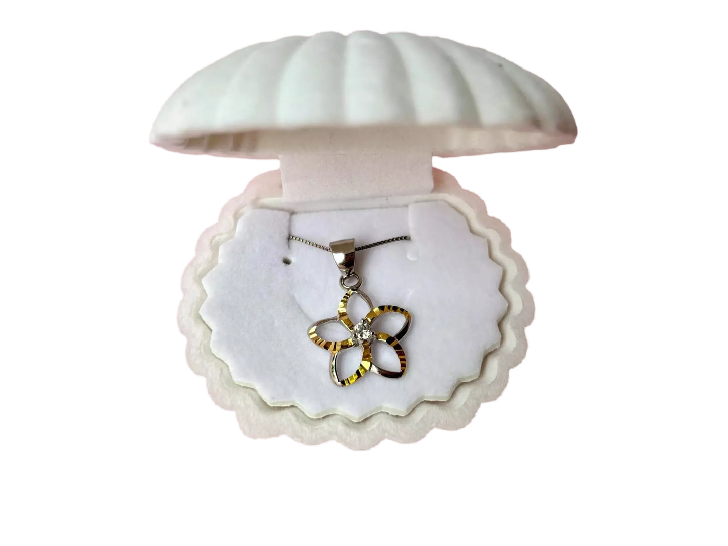 A necklace with a pendant in a white box with a scalloped edge, resembling a shell.