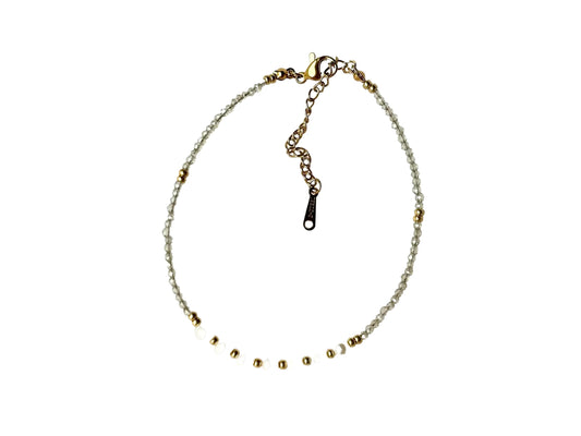 A necklace with a chain and a clasp, featuring a row of small, clear beads in gold and white colors.