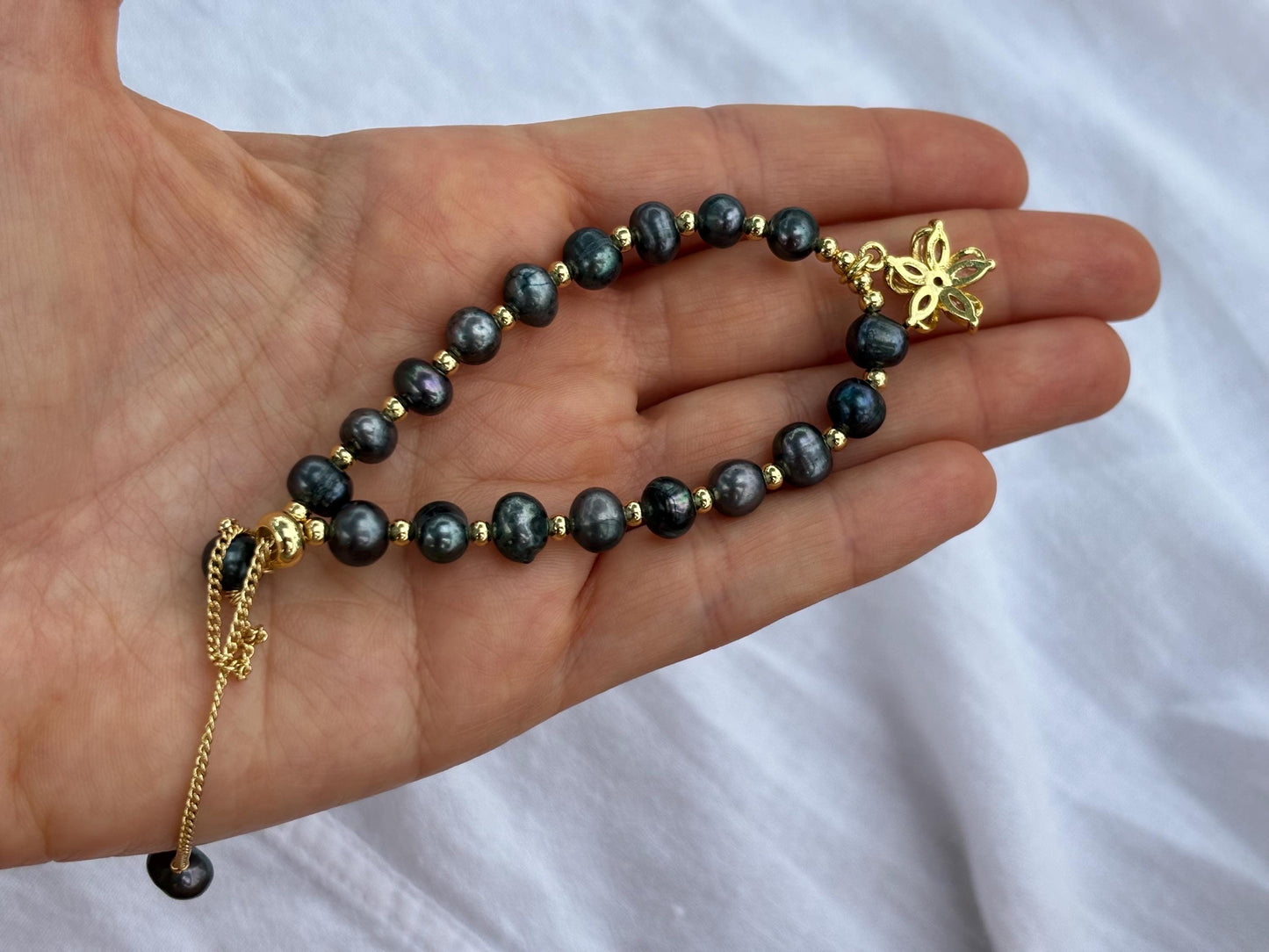 The Island Bloom – Black Pearl Bracelet with Gold Flower Charm