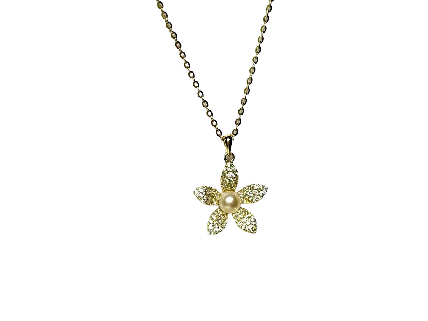 A delicate gold-colored necklace with a small, intricately designed flower pendant.