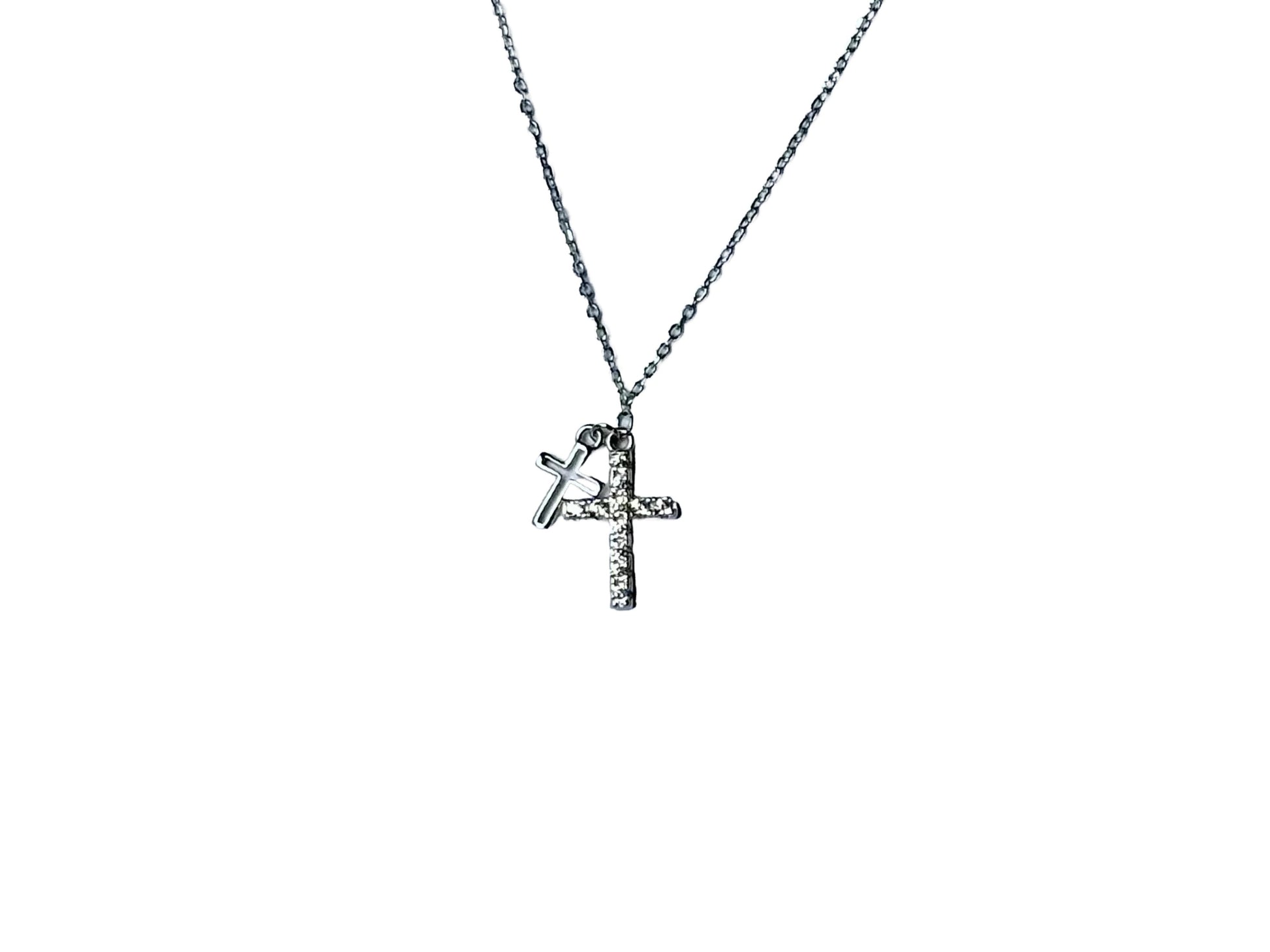 A silver cross pendant with a small charm attached to it.