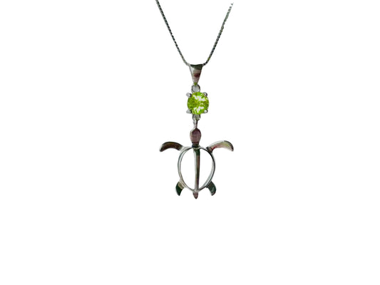 A silver pendant necklace with a green gemstone in the center.