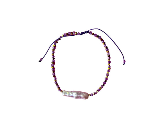 A beaded bracelet with a large pearl bead at the center.