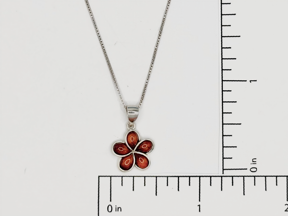 a silver necklace with a pendant in the shape of a flower.