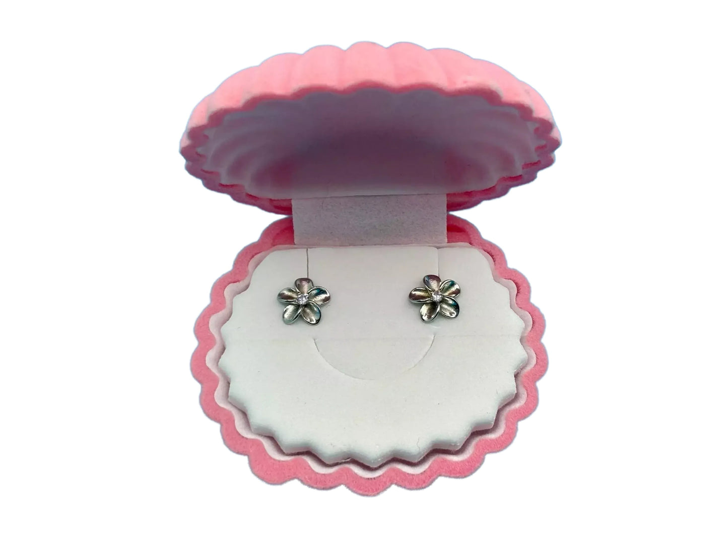 A pink shell-shaped jewelry box containing two silver earrings with flower-like designs.