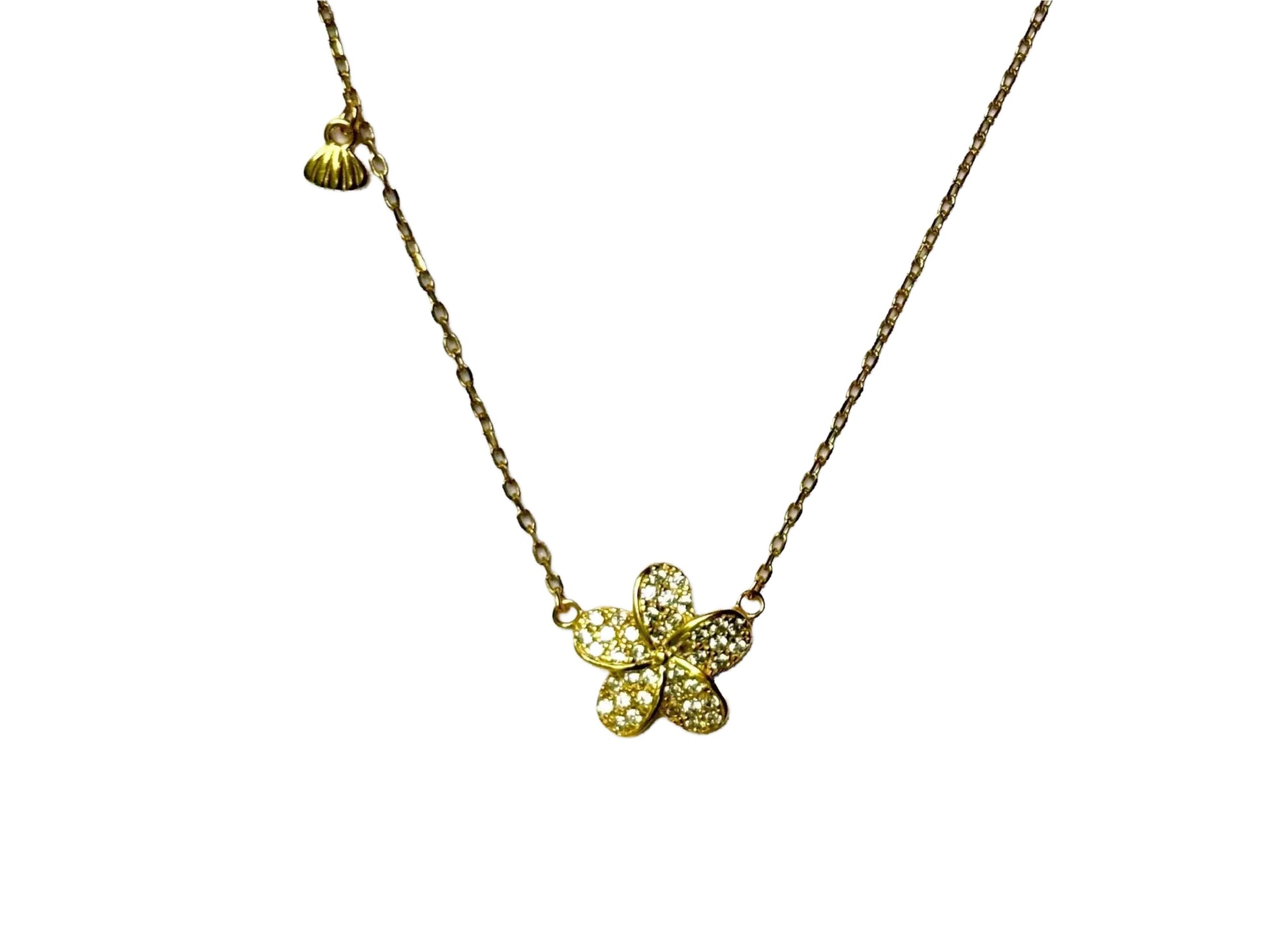 A gold necklace with a small, intricately designed flower pendant.