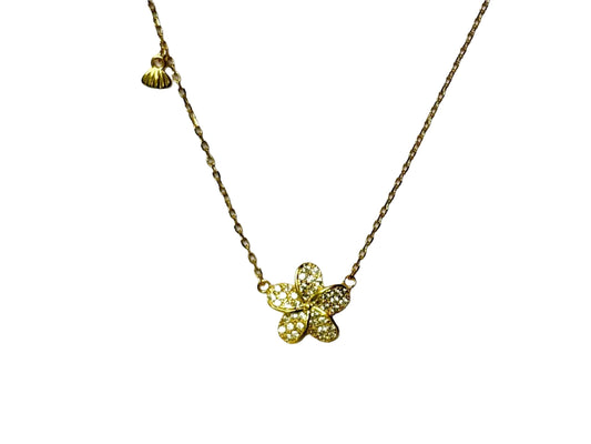 A gold necklace with a small, intricately designed flower pendant.