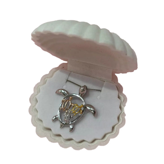 A necklace pendant in the shape of a turtle, displayed in a white shell-shaped box.