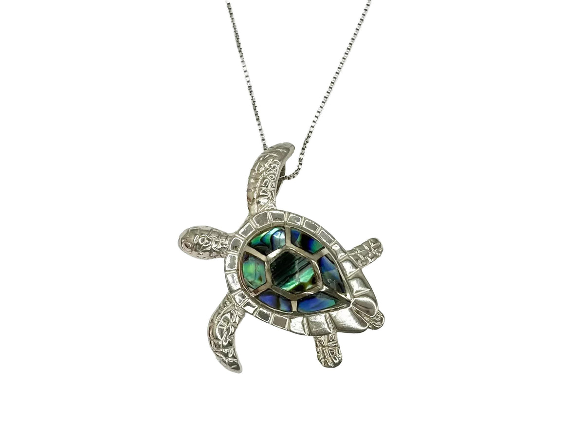 A silver necklace with a pendant in the shape of a sea turtle.