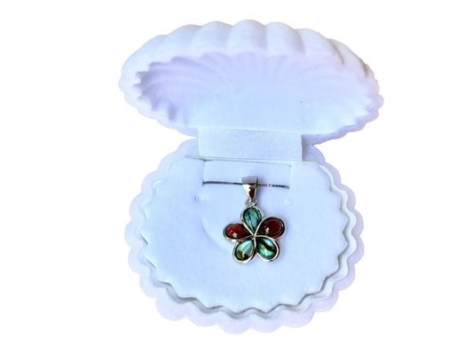 A pendant necklace with a flower-shaped pendant is displayed in a white shell-shaped jewelry box.