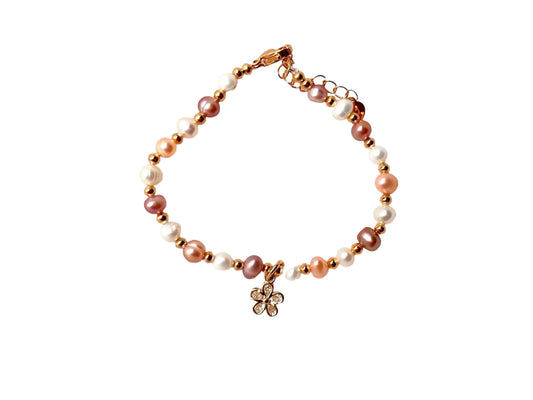 A bracelet made of small beads, including pearls and diamonds, with a charm pendant.