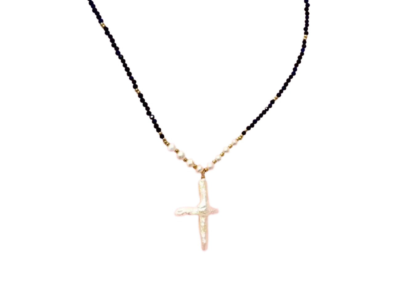 A necklace with a large cross pendant made of black beads and white beads.
