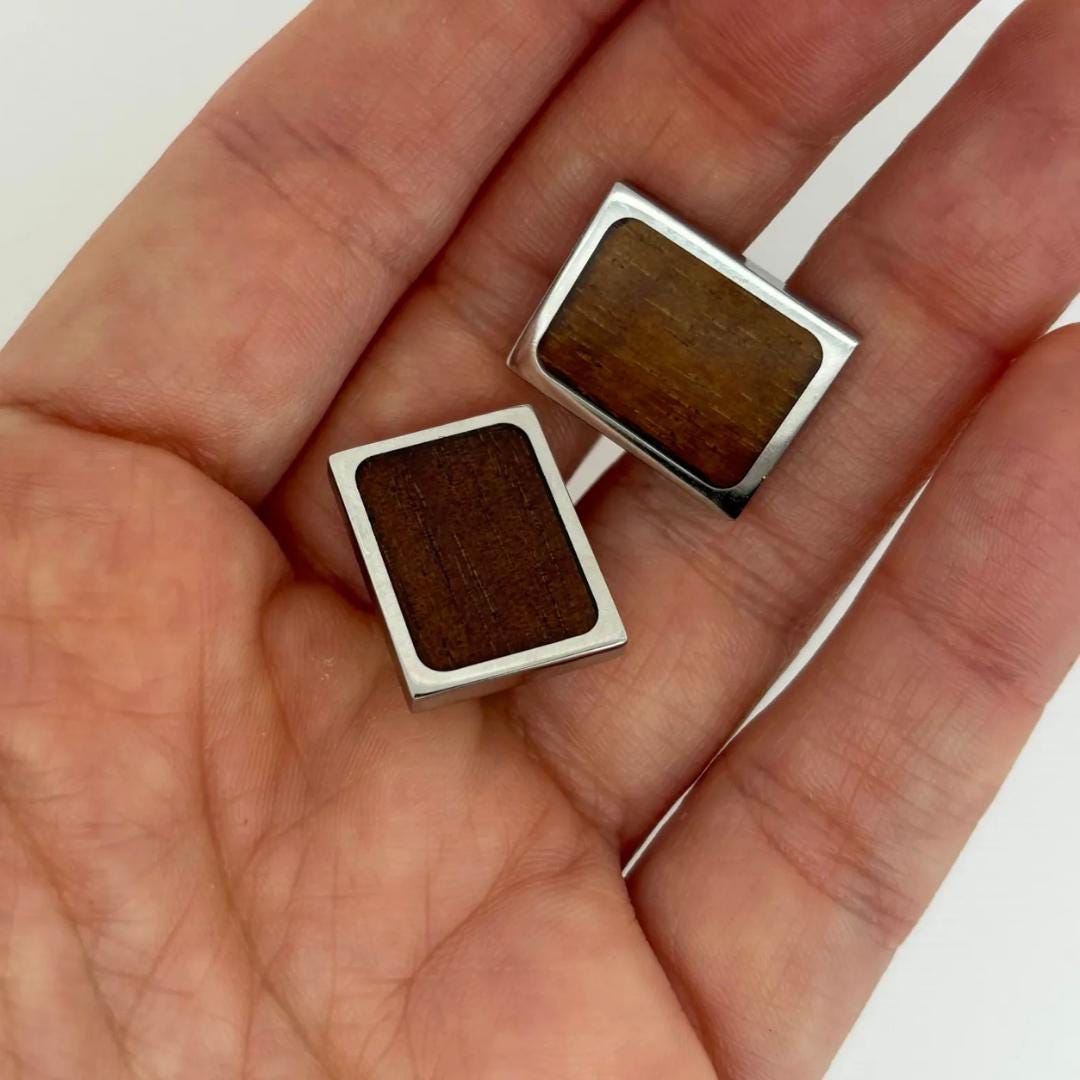 a pair of square wooden cufflinks on a person&#39;s hand