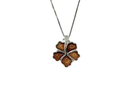 A silver necklace with a pendant in the shape of a brown flower.
