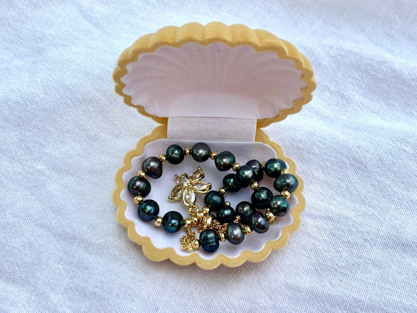 The Island Bloom – Black Pearl Bracelet with Gold Flower Charm