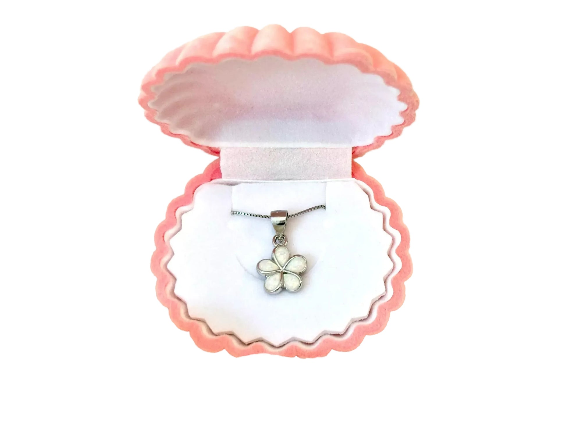 A pink-colored jewelry box containing a silver necklace with a white flower pendant.