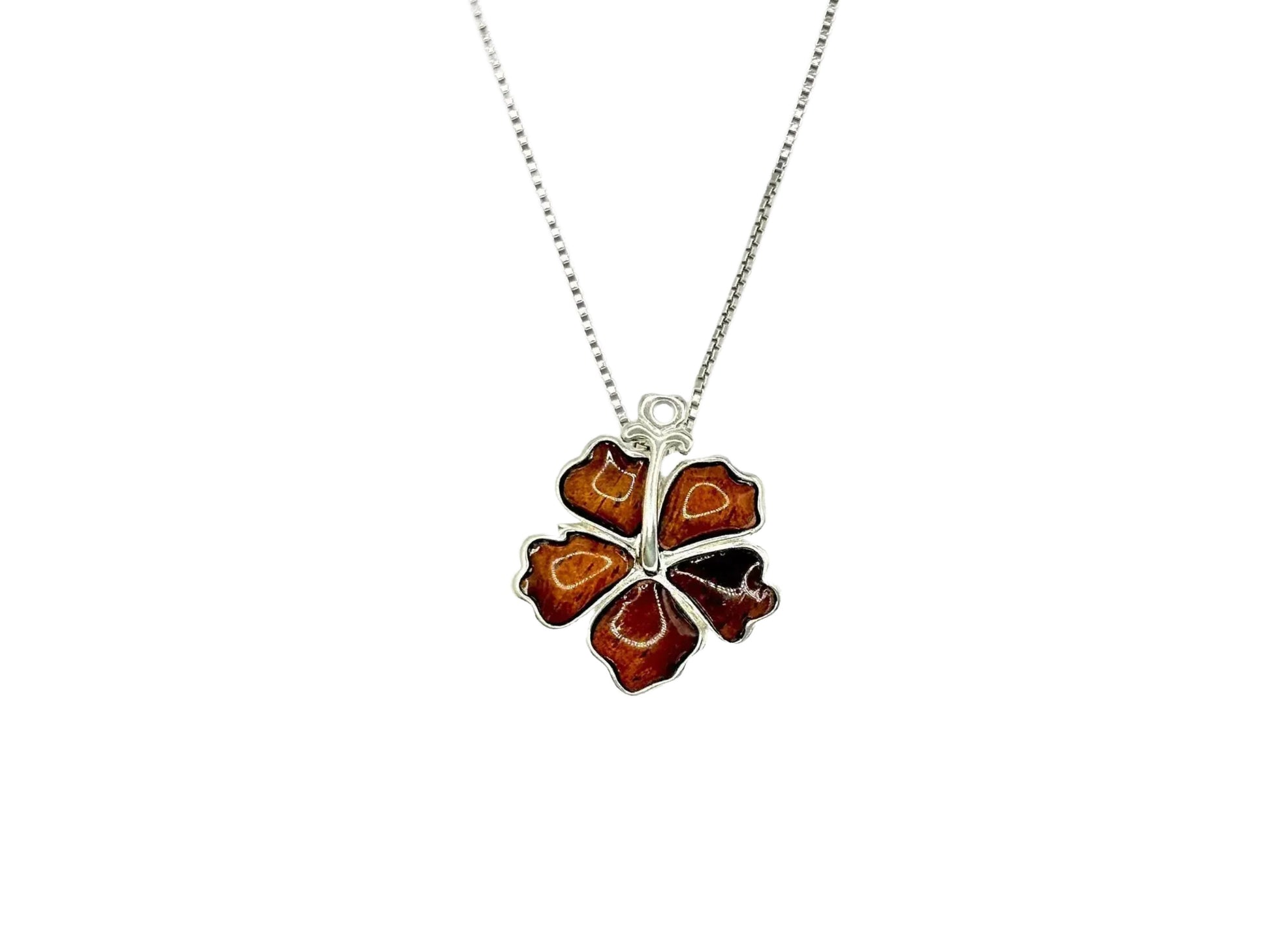 A silver necklace with a pendant in the shape of a flower.