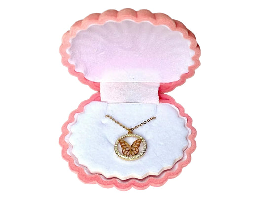 A pink and white jewelry box containing a necklace with a butterfly pendant.