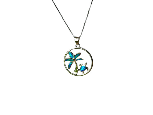 A silver pendant necklace with a circular design featuring a palm tree and a turtle.