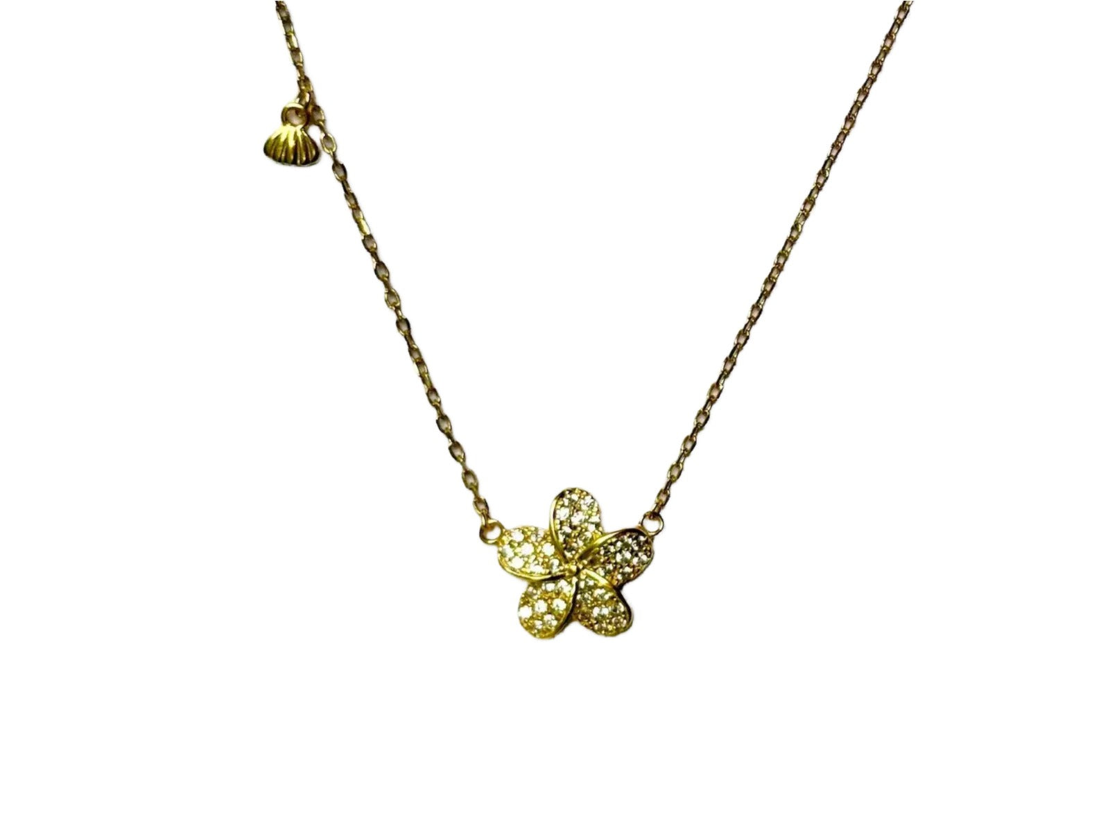 A gold necklace with a small, intricately designed flower pendant.