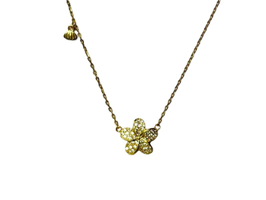 A gold necklace with a small, intricately designed flower pendant.