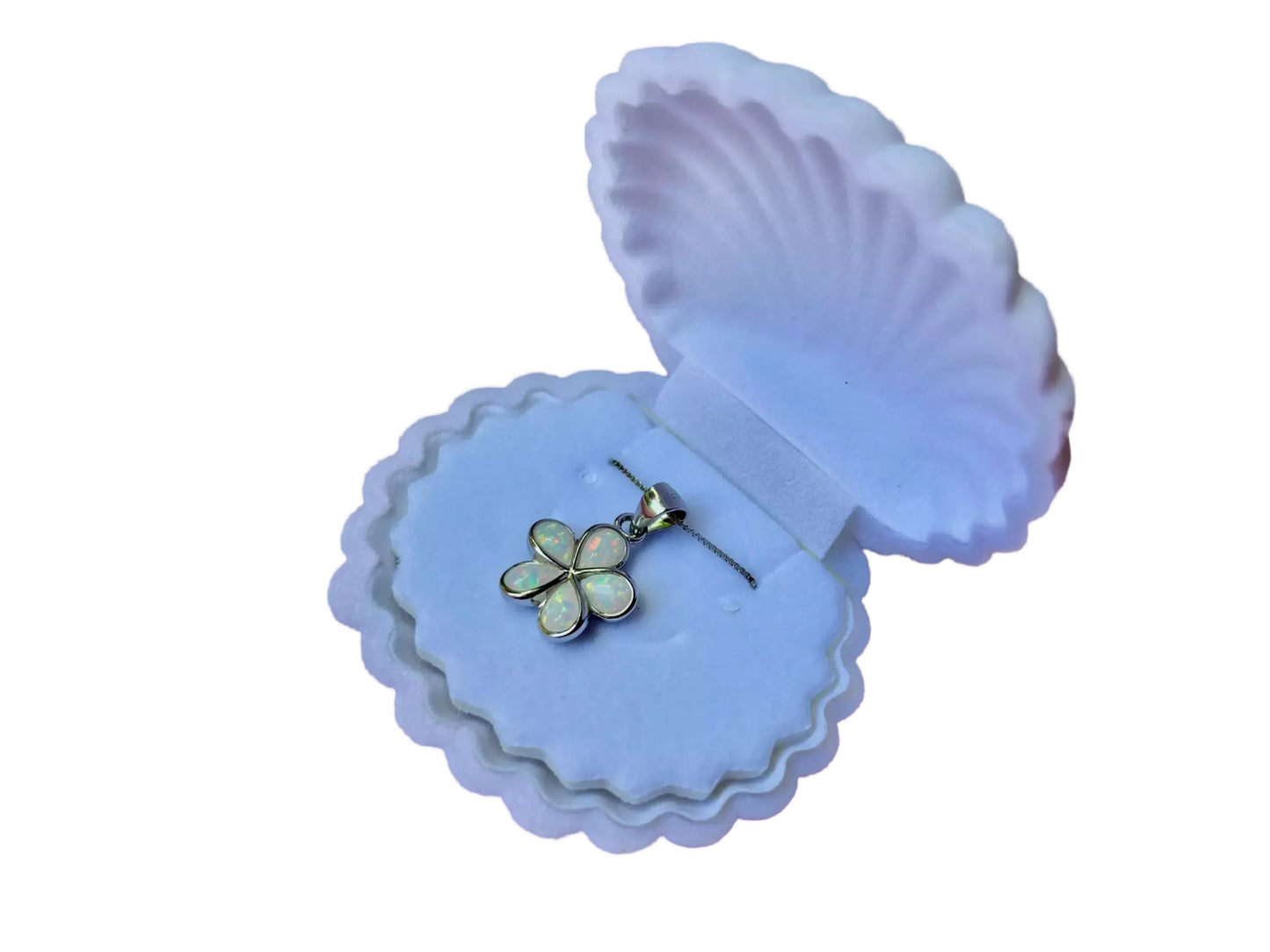 A pendant necklace with a flower-shaped charm is displayed in a white, scalloped-edge box.