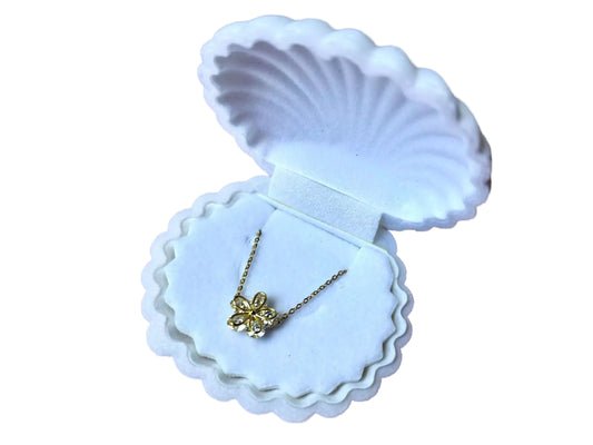 A white jewelry box containing a delicate necklace with a flower pendant.