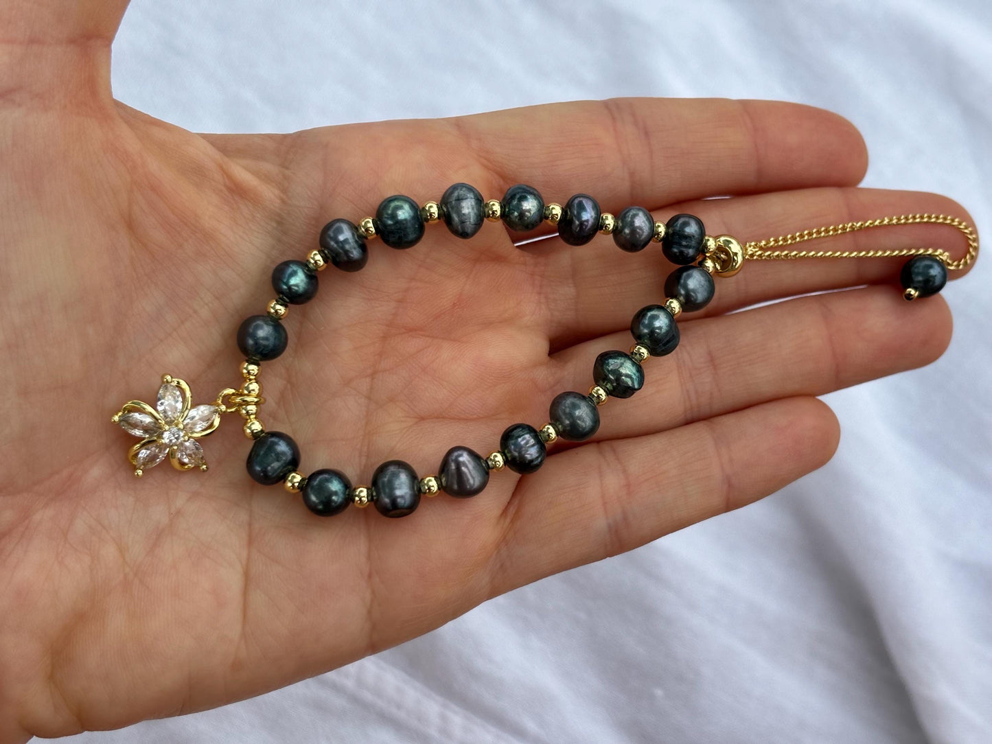 The Island Bloom – Black Pearl Bracelet with Gold Flower Charm